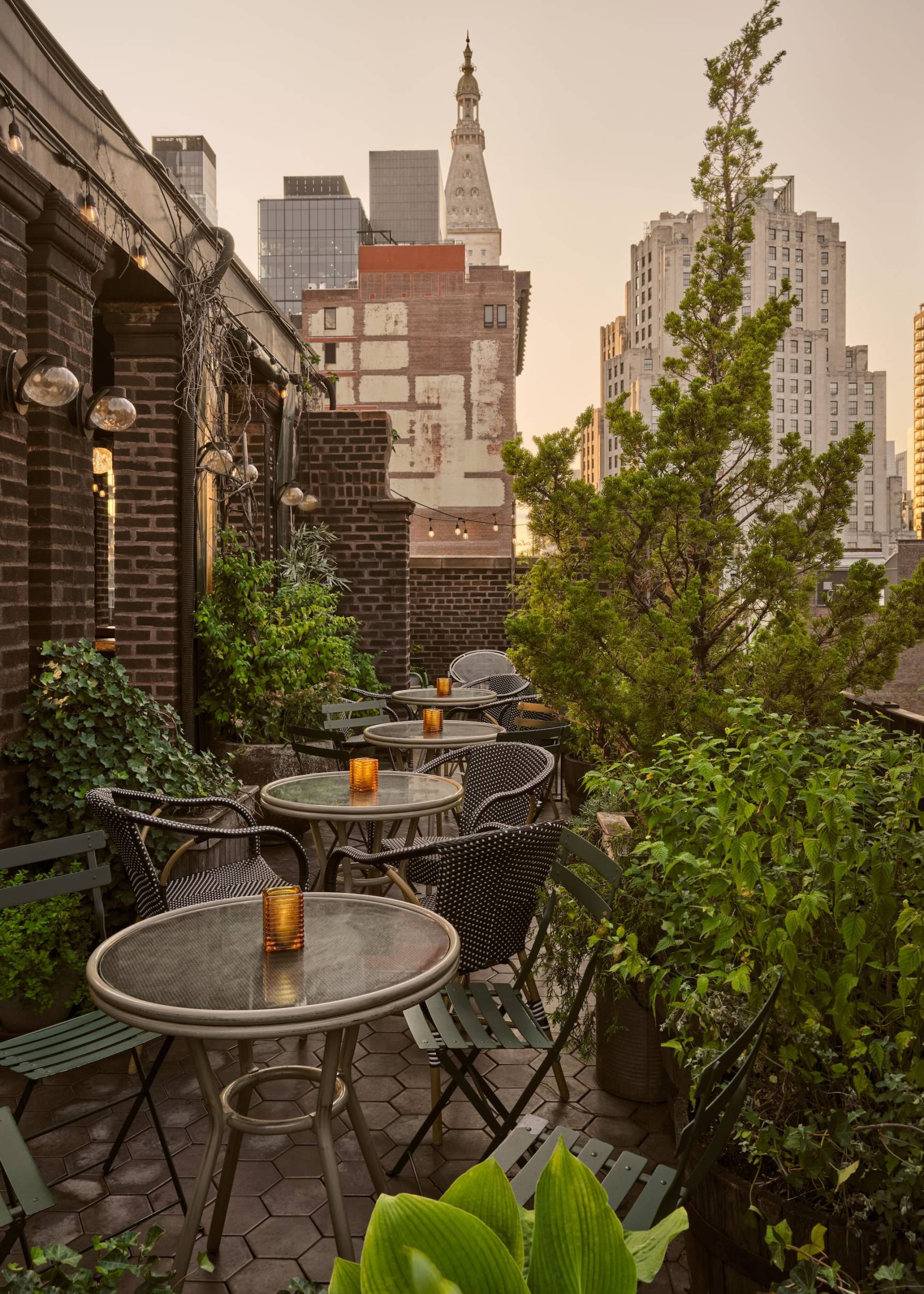 Broken Shaker’s rooftop terrace, with brick archways, greenery, and views of the Manhattan skyline